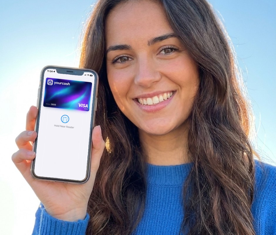 Mulher com o telemóvel a mostrar o cartão Visa Yourcash pronto a pagar